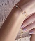 mano de mujer con uñas nude con pulsera fina dorada con estrella de seis puntas cubierta de cristales regulable y elegante