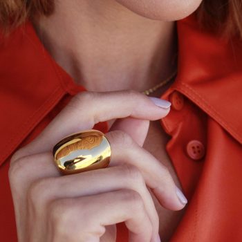 bella mujer con detalle de anillo macizo grande de oro en dedo anular
