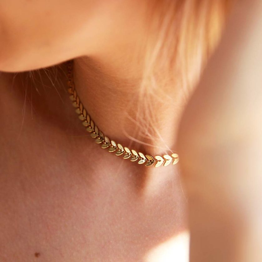cuello de mujer rubia con collar gargantilla dorado con diseño de espiga