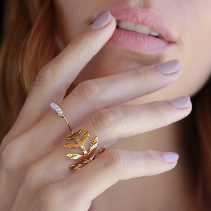 manos de mujer con anillo fino con detalle de cinco perlas naturales pequeña en el frente