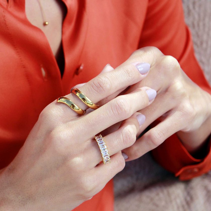 manos delicadas de mujer con anillo dorado entrelazado al dedo indice