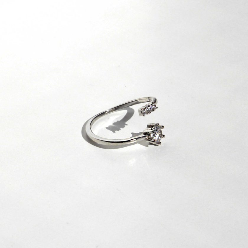 bello anillo de plata con abierto que se entrelaza al dedo y cristales