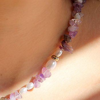 detalle de collar de cuarzo con tonos lilas y violetas en cuello de mujer